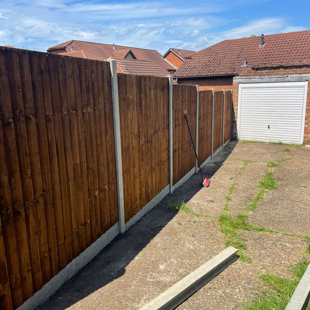New dark wooden fence with concrete posts